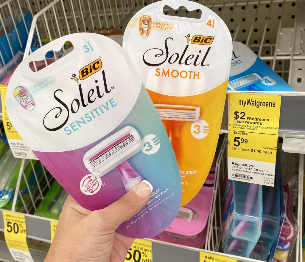 person holding up two packages of bic soleil razors in from of yellow walgreens sale tag