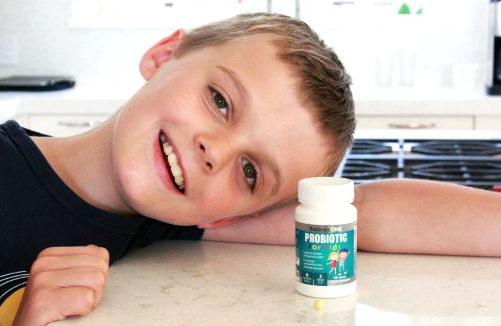 boy next to a bottle of probiotics