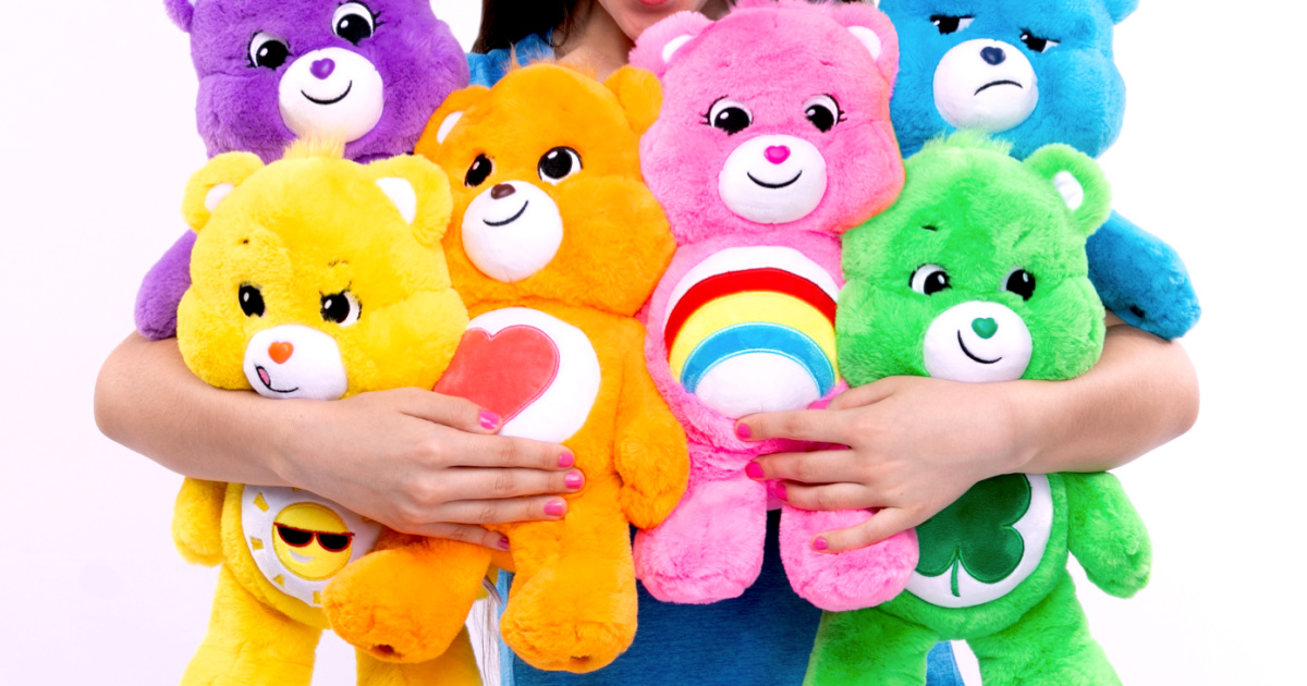 girl holding six Care Bears Plush toys