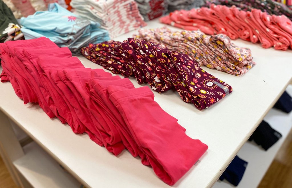 pairs of folded girls leggings on a white display table