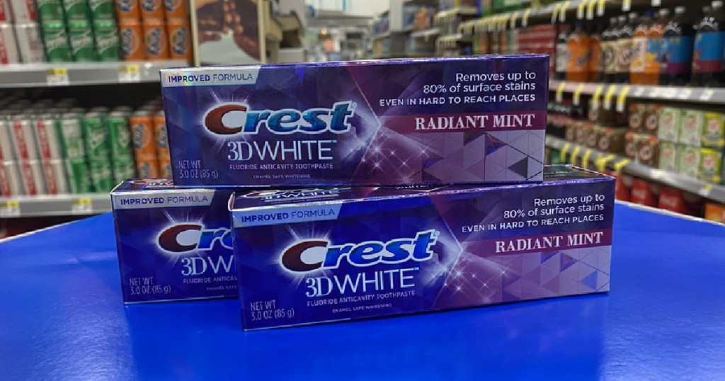 three boxes of toothpaste on blue table in store