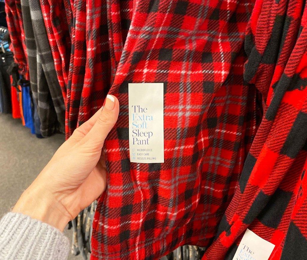 hand holding a pair of red and black plaid sleep pants
