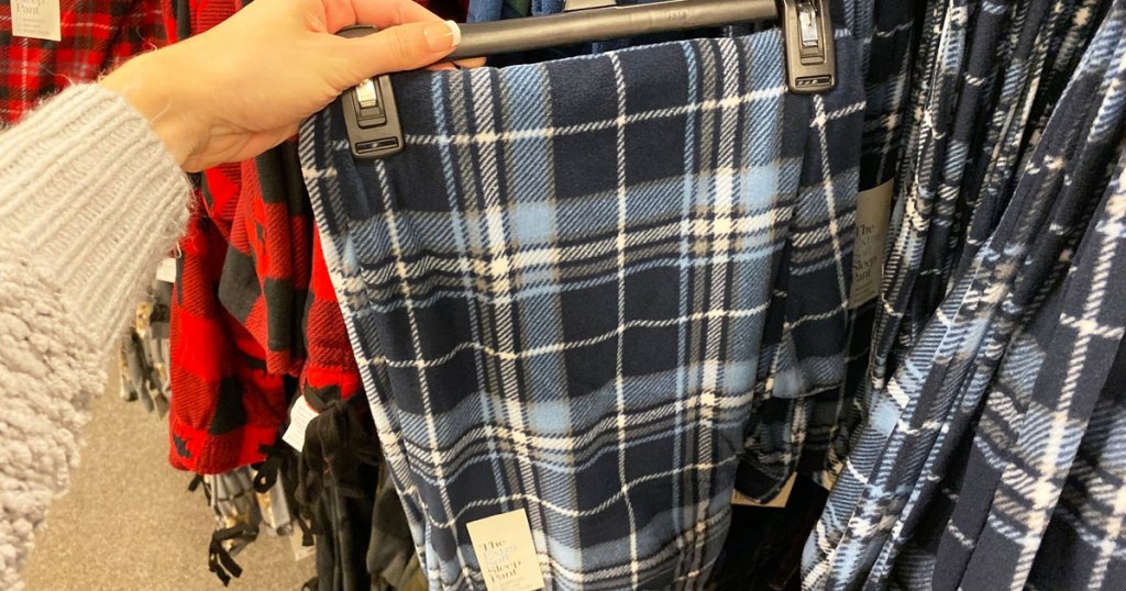 hand holding a pair of blue and white plaid sleep pants