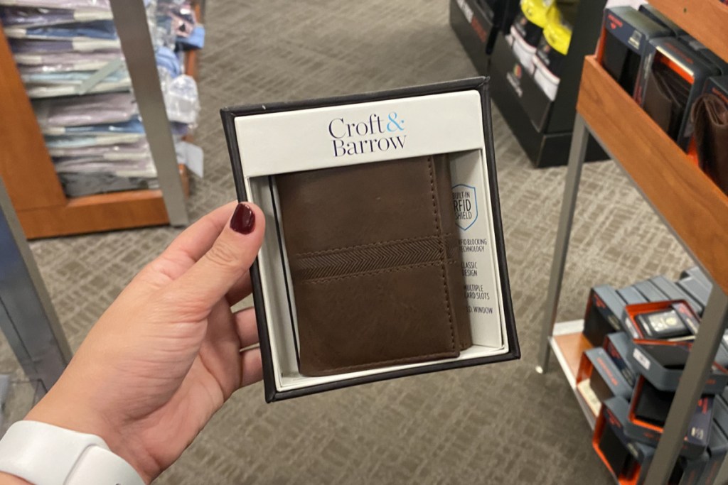 hand holding a brown tri fold wallet at kohl's