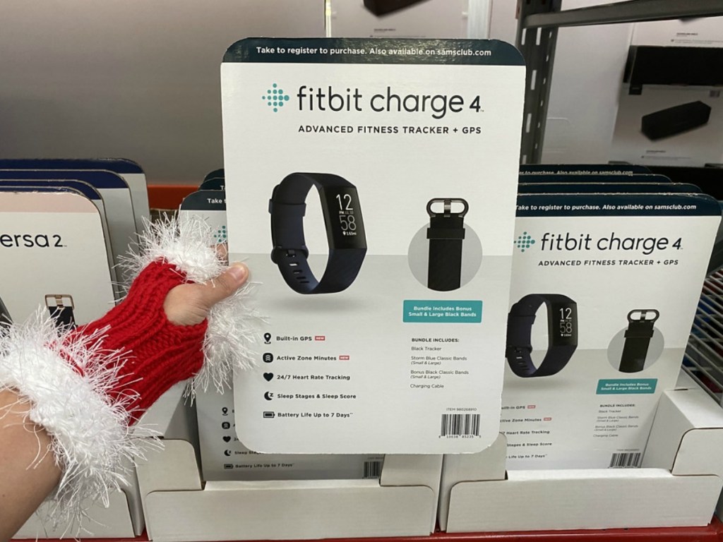 lady with a santa glove holding a fitbit tracker