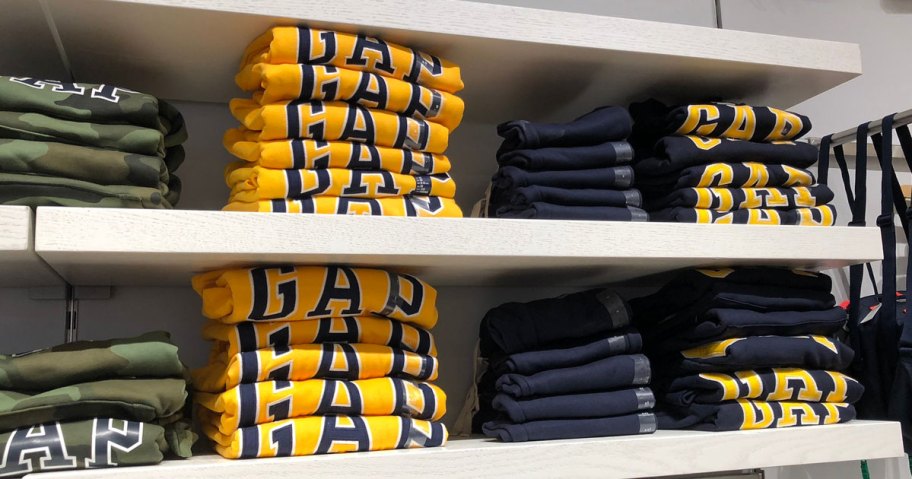 folded stacks of gap sweatshirts on white display shelves