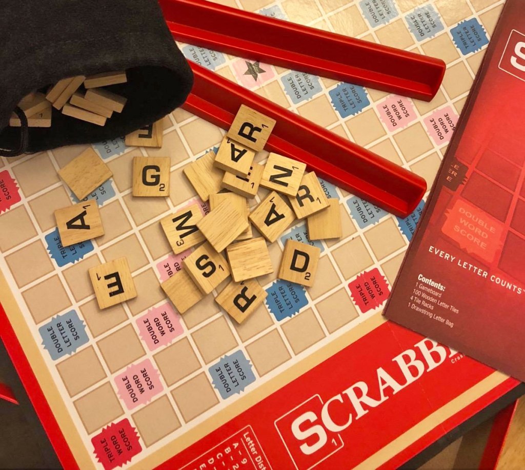 scrabble board game with letters and tile holders on top of board