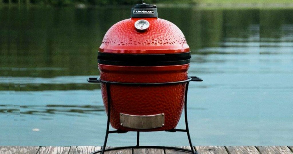 small red egg shaped grill on dock near water