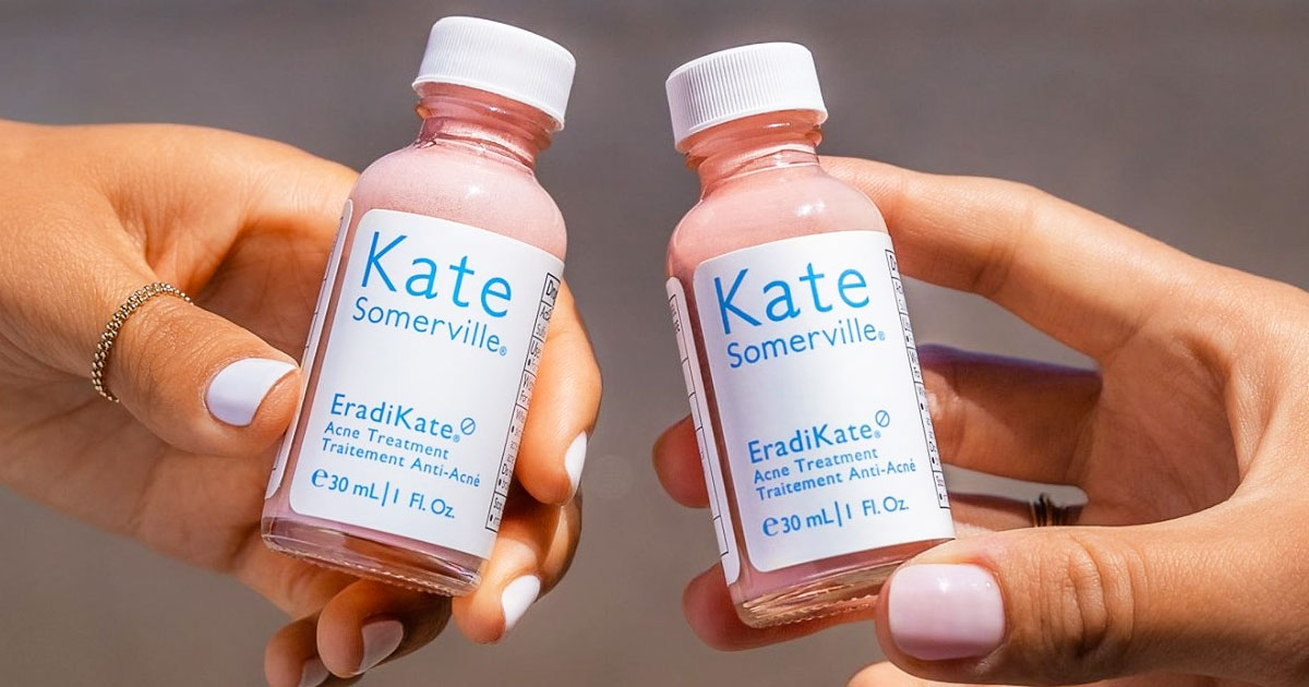 two women with light pink nails holding up two bottles of Kate Somerville acne treatment up next to each other