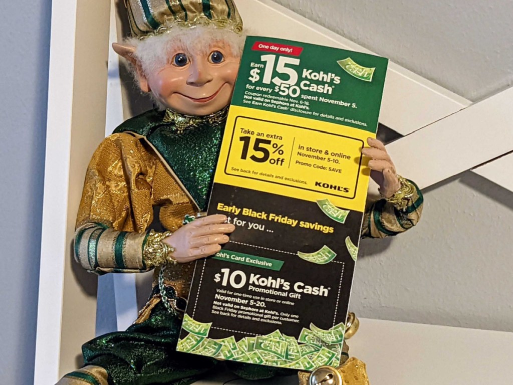toy elf holding store flyer on white shelf