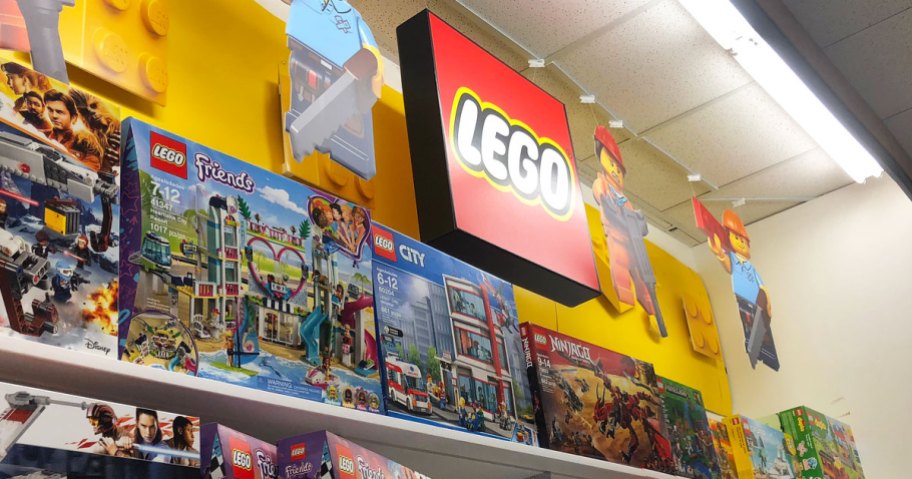 red lego sign and minifigures hanging above lego display shelves at kohl's