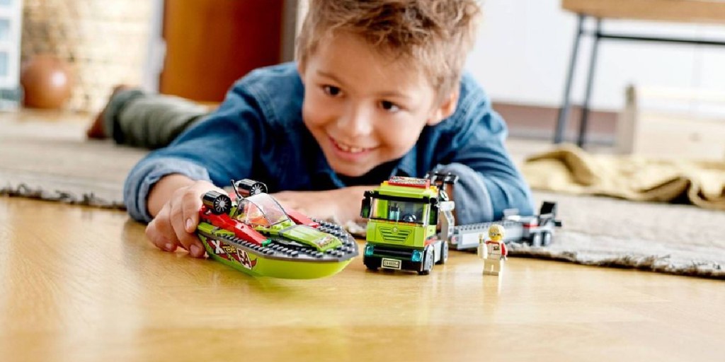 boy playing with LEGO boat transporter