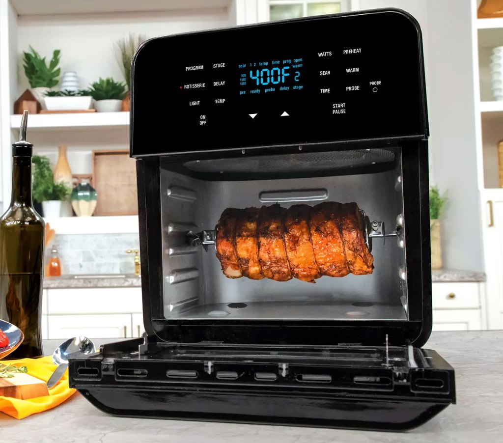 large black nuwave air fryer oven with door open showing rotisserie meat inside