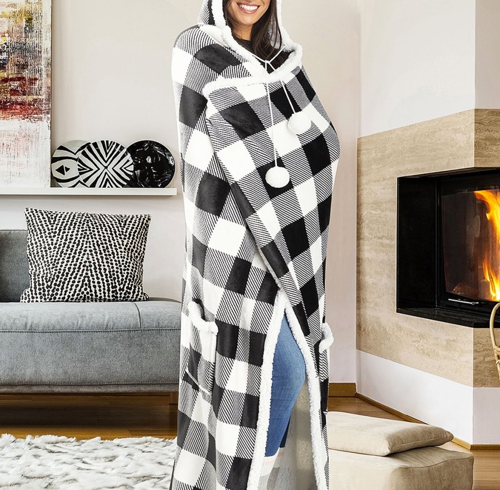 woman wrapped in a black and white buffalo plaid patterned blanket with a hood