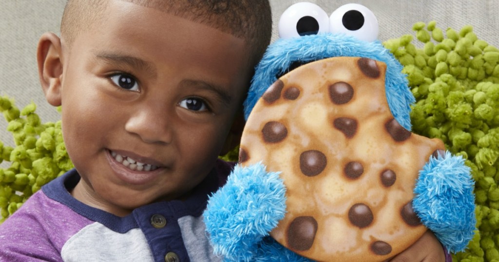 little boy holding Sesame Street Peekaboo Cookie Monster plush toy