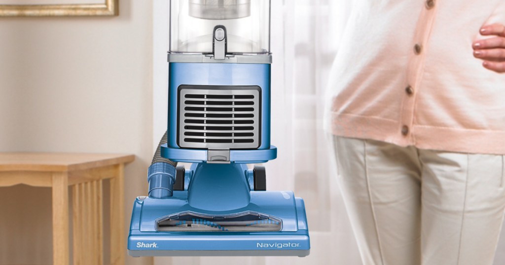 woman holding up blue vacuum