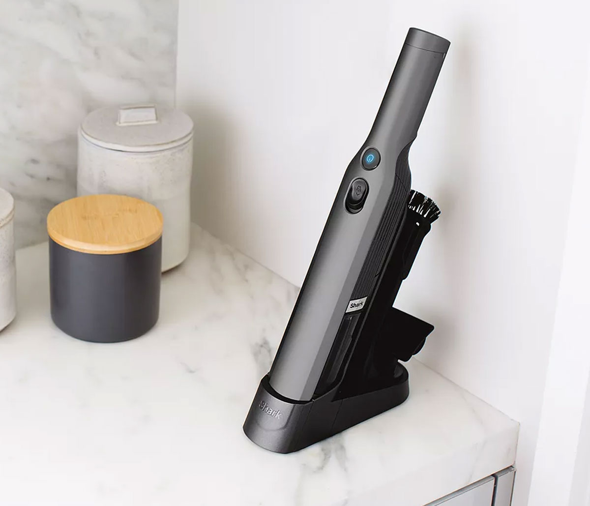 black mini cordless vacuum on charging stand on a kitchen counter