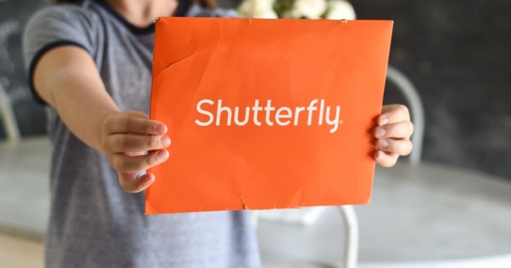 child hand holding shutterfly envelope