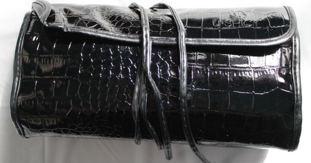 shiny black rolled up makup bag