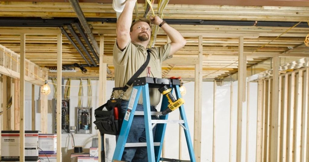 Man on blue 6-ft Werner ladder in an unfinished basement