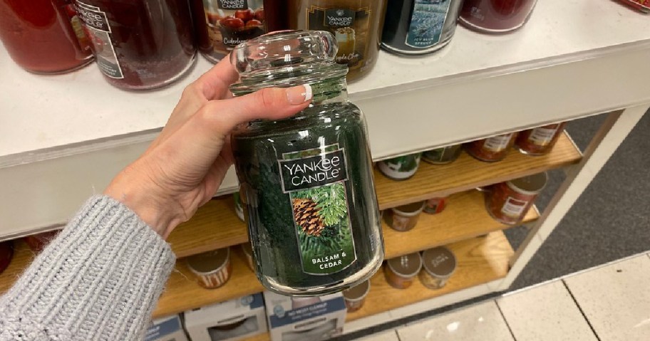 hand holding a Yankee Candle Large Jar Candle in Balsam & Cedar