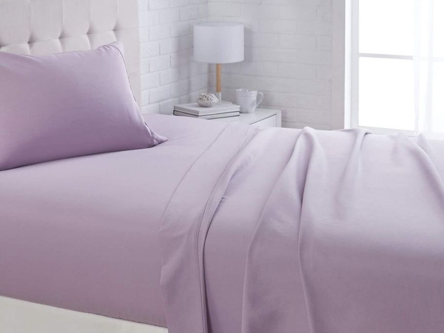 bed with purple sheets