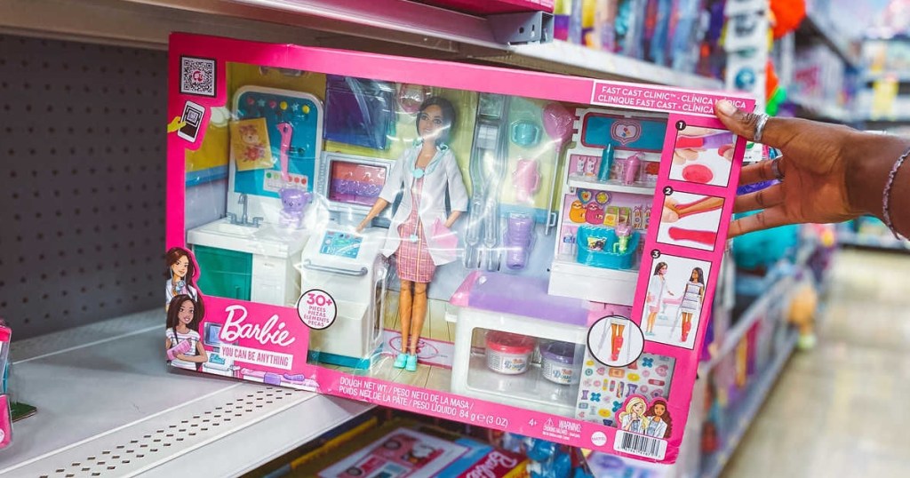holding a Barbie doctor playset