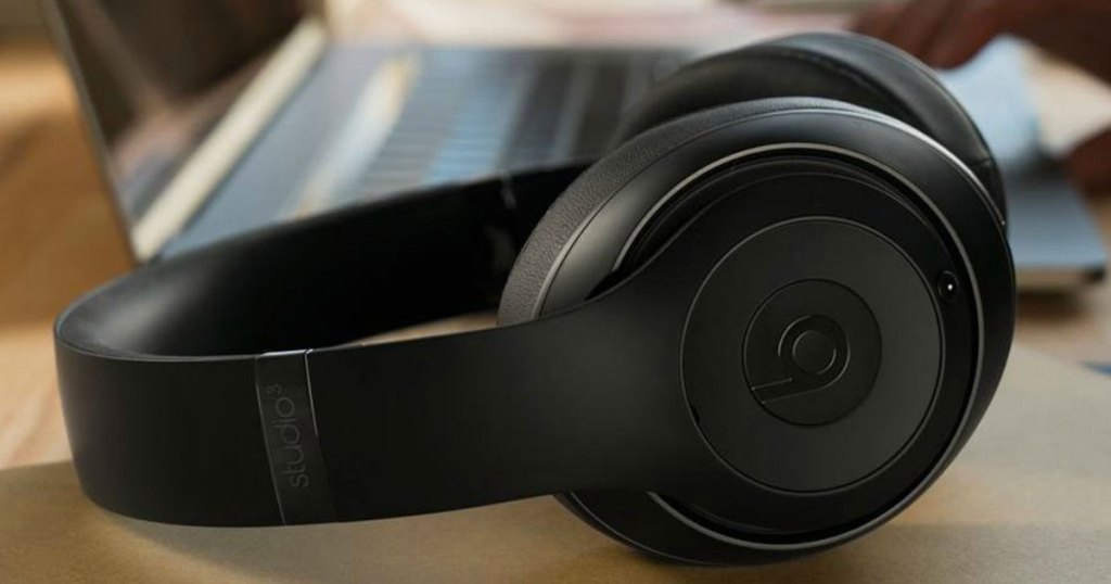 black pair of beats studio headphones laying near laptop