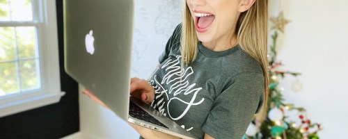 woman holding laptop looking happy