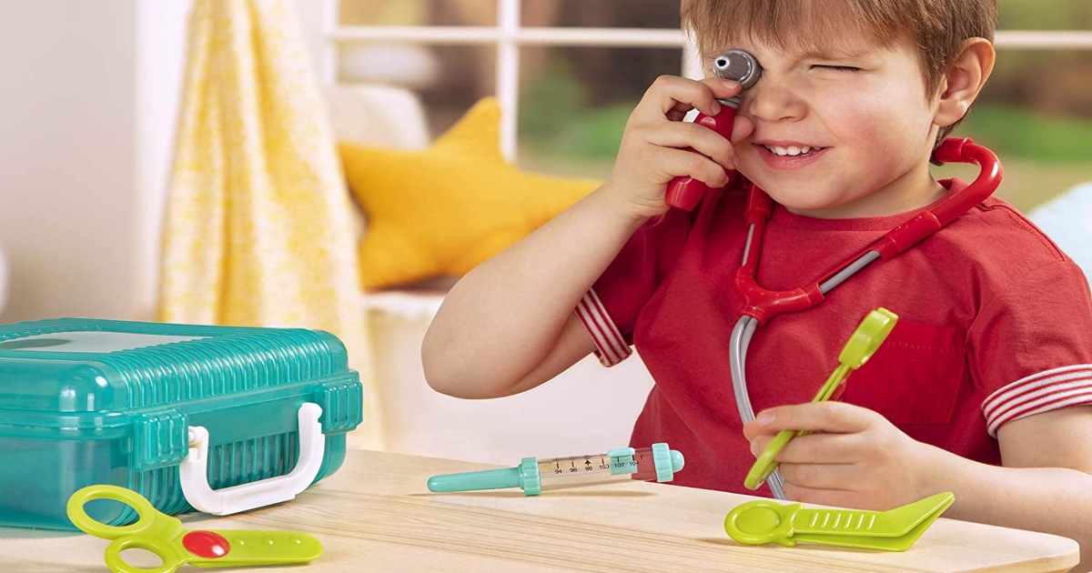 boy at a table playing with a pretend doctor kit