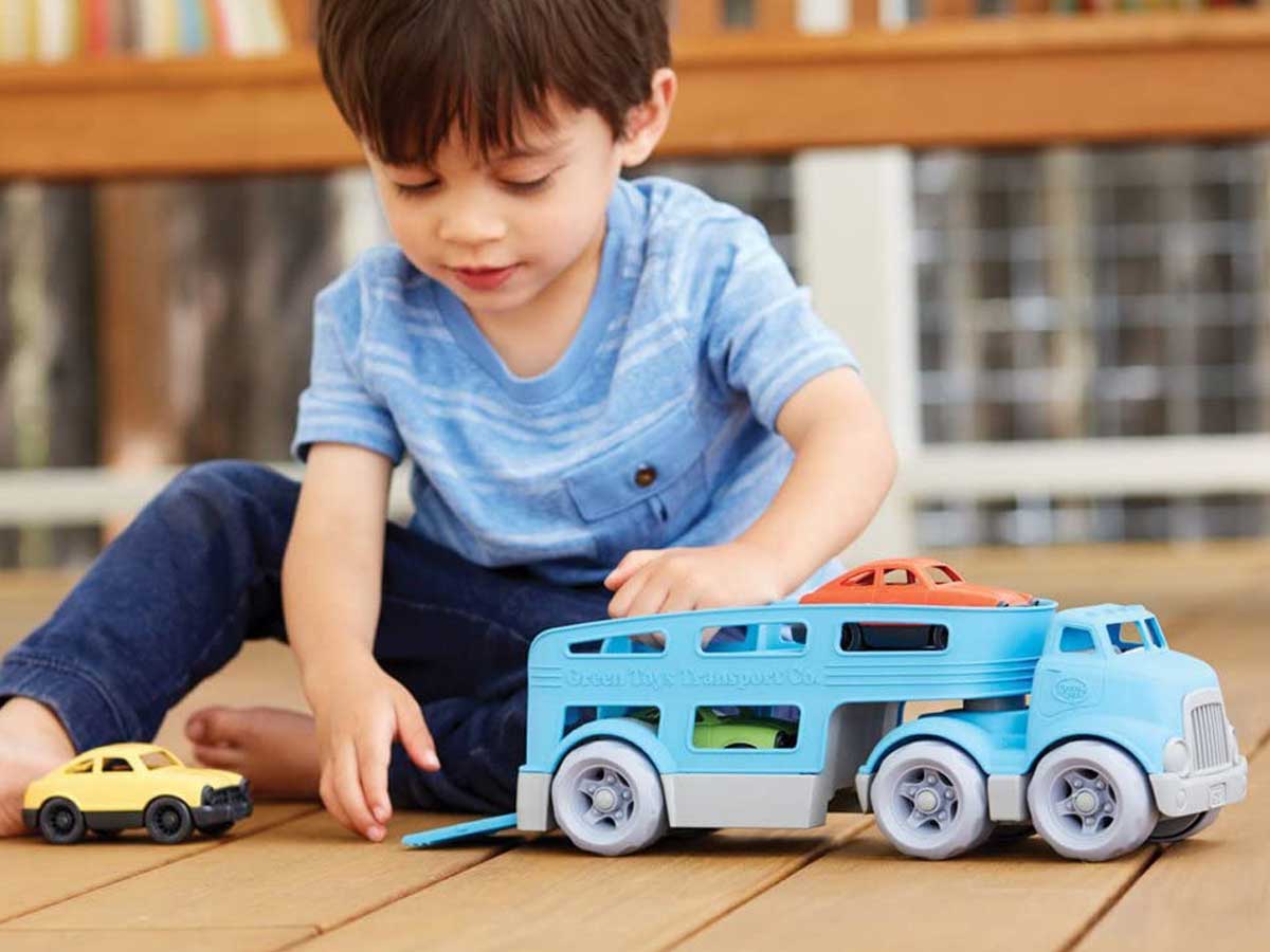 little boy playing with car carrier and cars