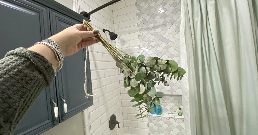 holding a bouquet of eucalyptus in the shower