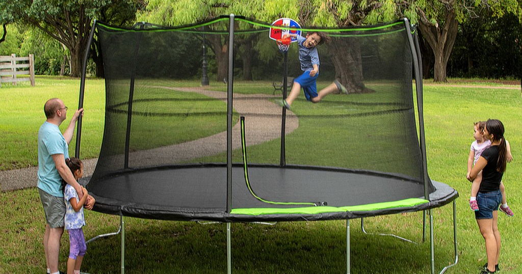 kid jumping on a Jump King 14ft Trampoline With Basketball Hoop