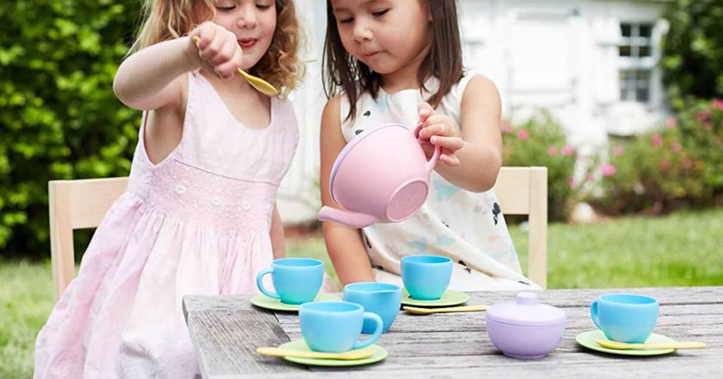 little girls playing outside with a tea set