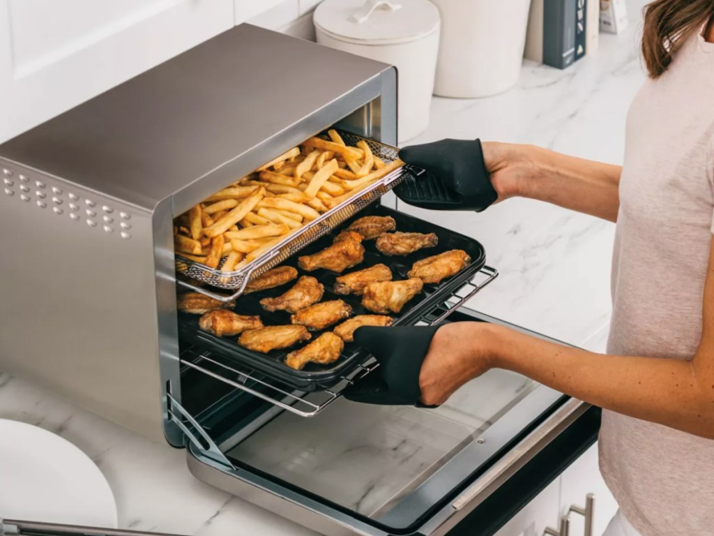 woman taking food out of the ninja foodi convection oven