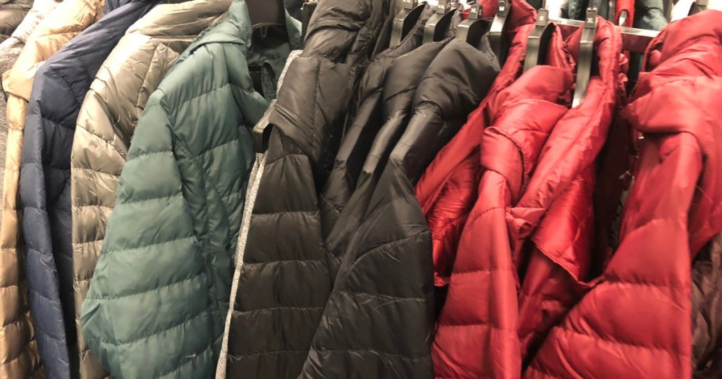 assorted colors of puffy jackets on rack in store