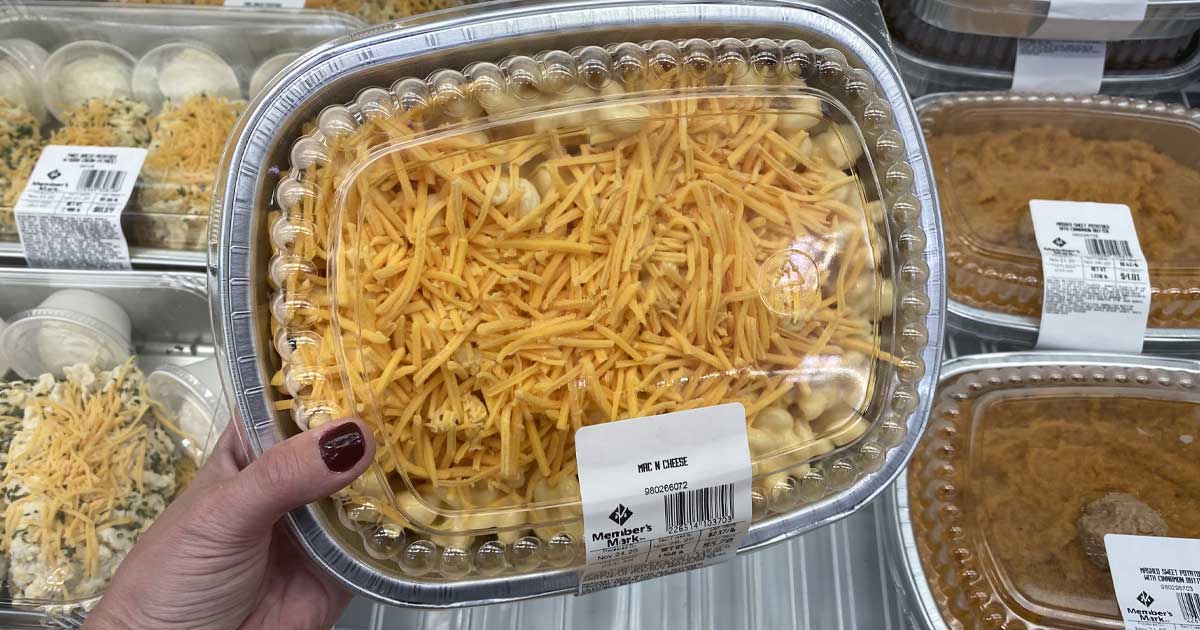 hand holding a prepackaged container of prebaked mac and cheese in store