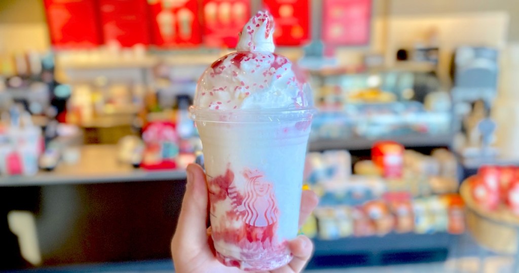 hand holding a red and white santa frappuccino