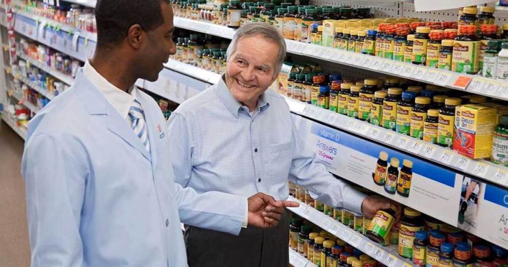 senior man shopping at Walgreens with staff member