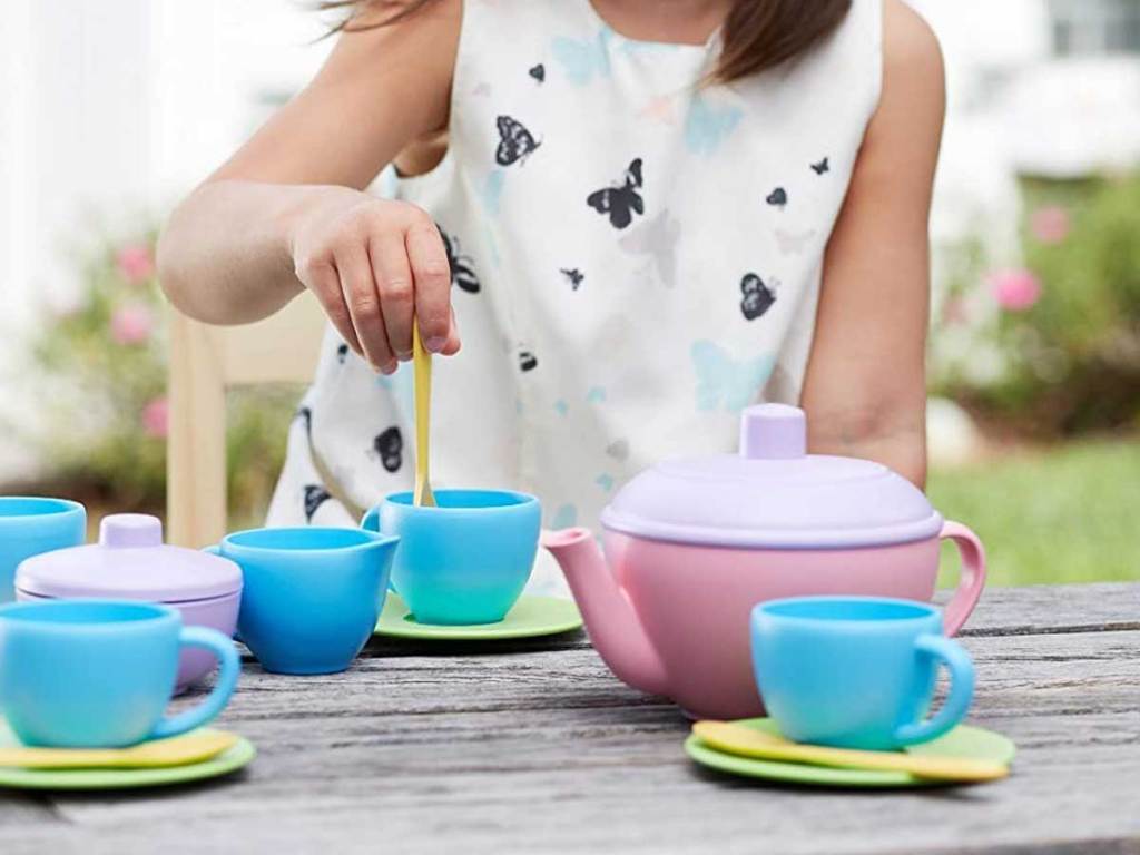 little girl playing with tea set