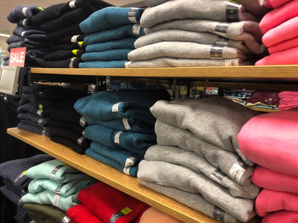 store shelf with sweatshirts of different colors on it