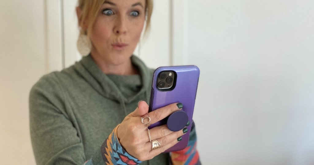 woman looking at her phone with a surprised face