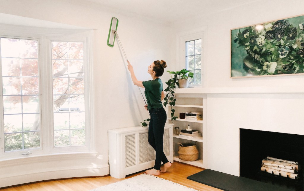 woman using turbo mop on white wall