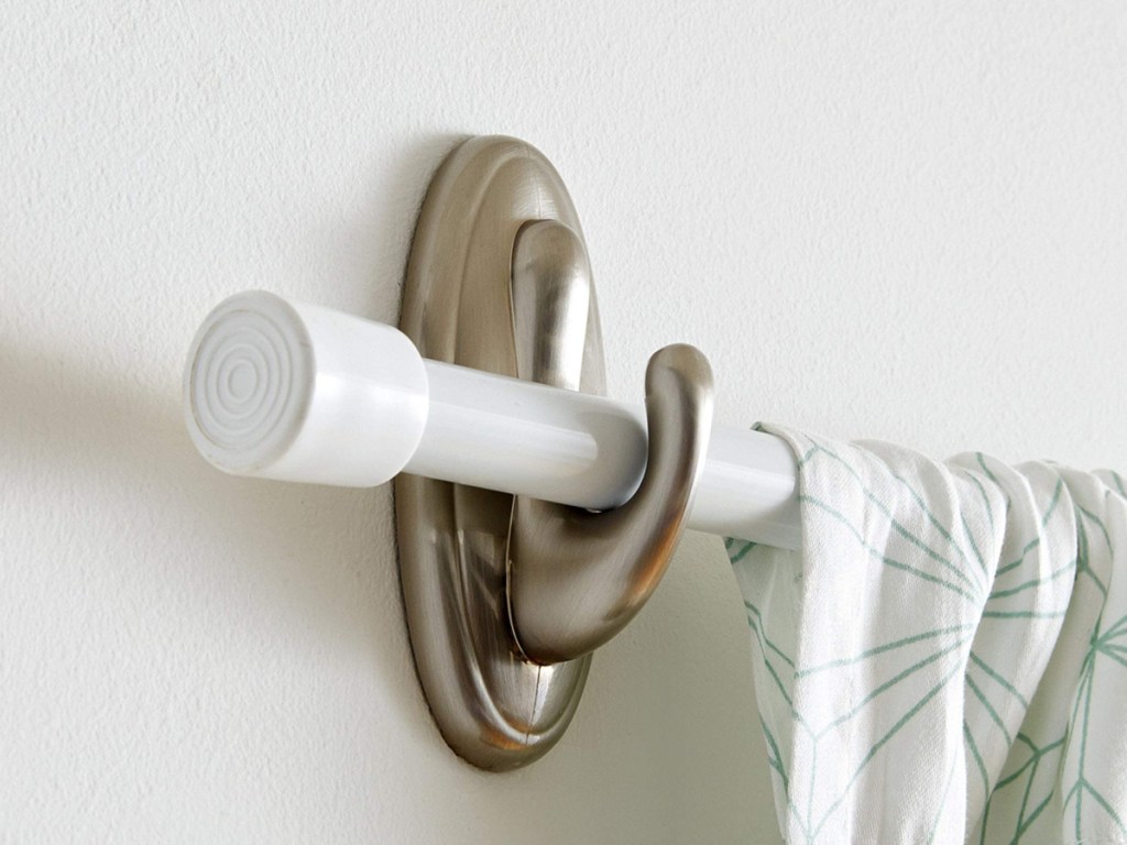 silver plastic command hook holding a curtain rod