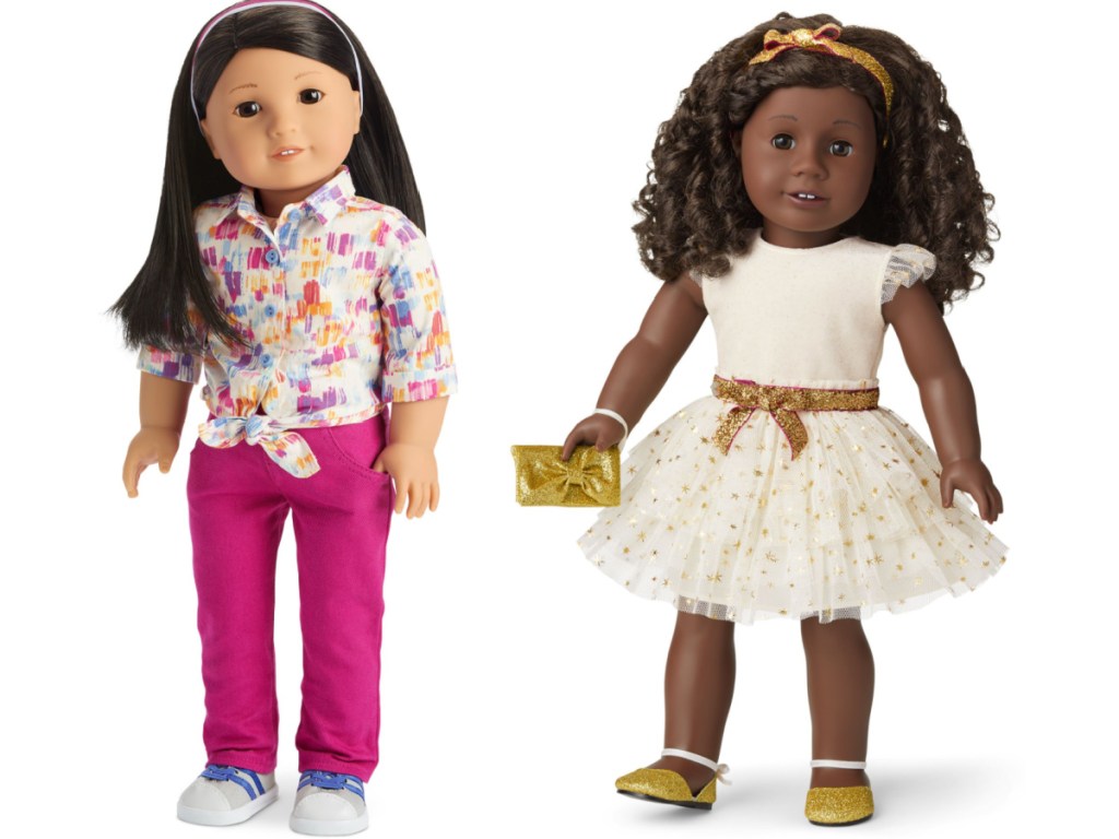 2 american girl dolls standing next to each other