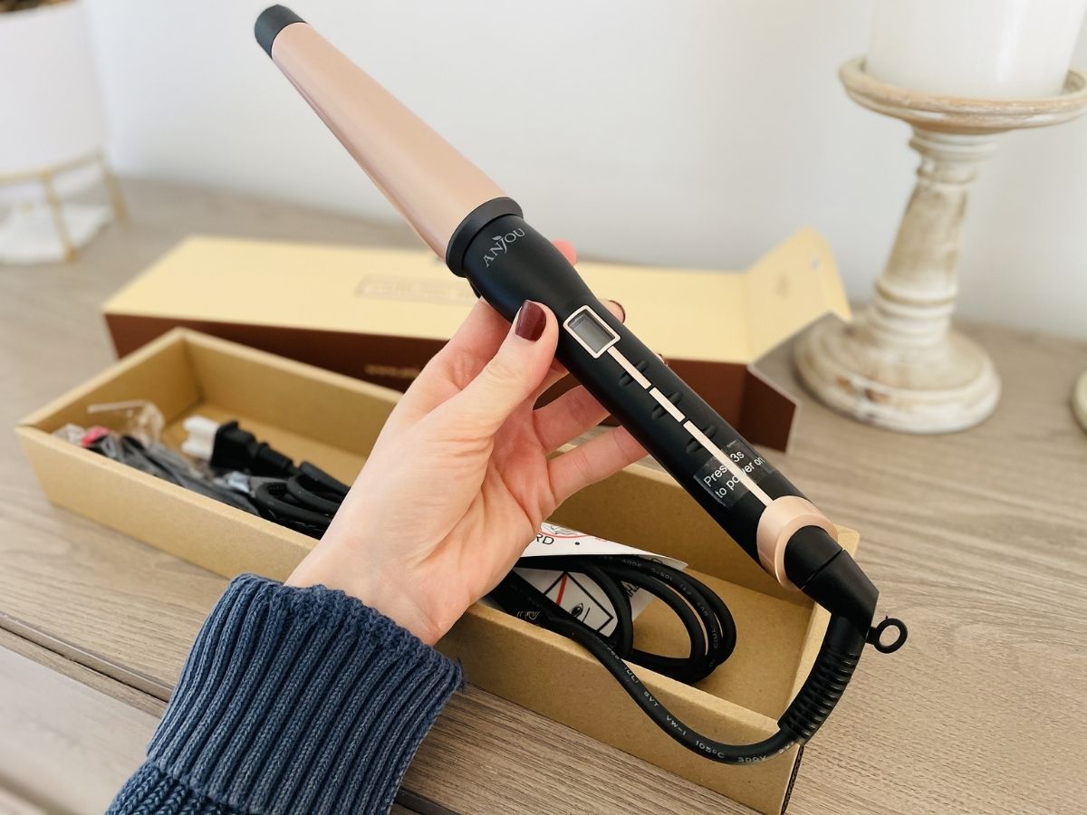woman holding hair curling wand
