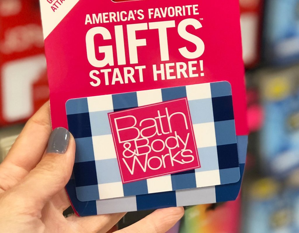 person holding up a blue and white gingham printed bath & body works gift card