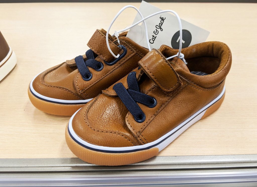 brown leather pair of toddler boys sneakers with velcro strap and navy blue laces