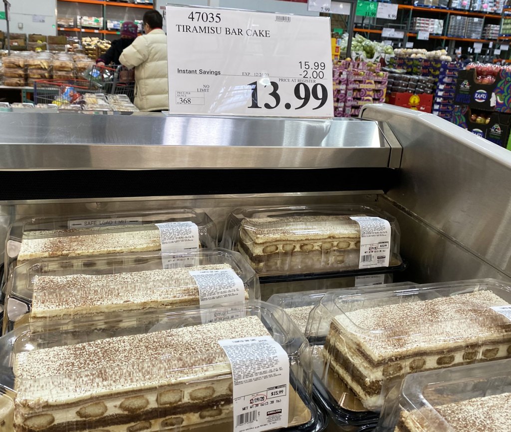 tiramisu bar cakes in plastic clamshell containers in refrigerated case at costco with $13.99 sale sign above them