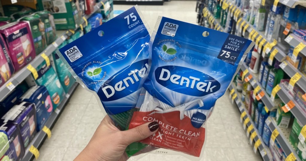 hand holding up 2 bags of Dentek Floss Picks